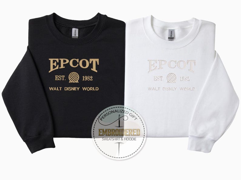 May include: Black and white sweatshirts with the text "EPCOT EST. 1982 WALT DISNEY WORLD" embroidered in gold and white. The sweatshirts have a crew neck and long sleeves. A personalized gift label is in the foreground.