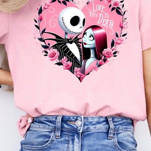 May include: Pink t-shirt with a graphic of Jack Skellington and Sally from The Nightmare Before Christmas. The graphic is in a heart shape with pink roses and the text "Love You To Death".