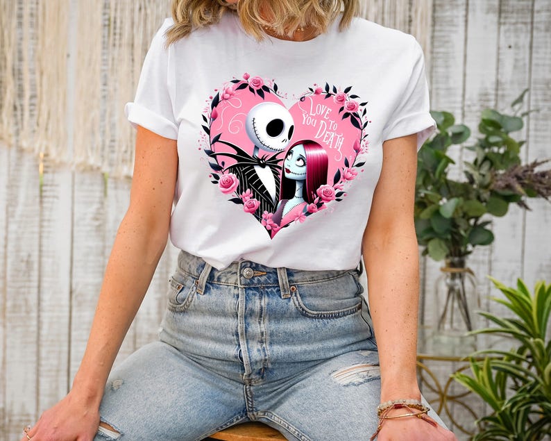May include: White t-shirt with a pink heart graphic featuring Jack Skellington and Sally from The Nightmare Before Christmas. The graphic includes the text "Love You To Death".