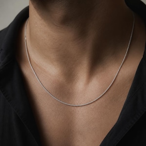 slim platinum chain necklace 1.4mm worn on chest with open shirt minimal unisex styling