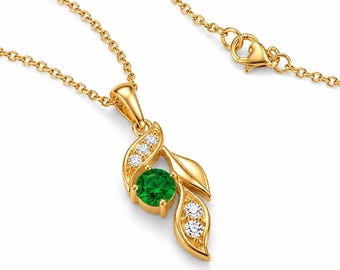 Può includere: Una collana con pendente in oro caratterizzata da una pietra preziosa rotonda di un verde vivace incastonata in una montatura a forma di foglia. Le foglie dorate sono impreziosite da cinque piccole pietre chiare a taglio rotondo e chiusura a moschettone.