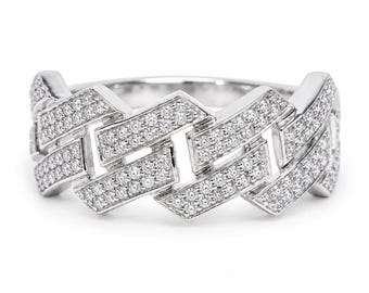 Può includere: Un anello color argento con un design a catena a maglia cubana. La superficie di ogni maglia intrecciata è densamente incrostata di numerose piccole pietre trasparenti a taglio rotondo che conferiscono un aspetto scintillante all'intero anello.