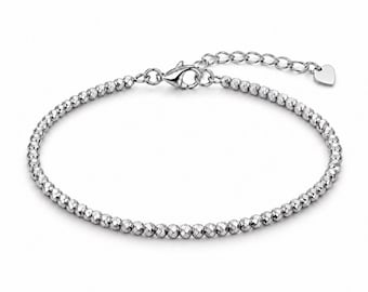 Peut inclure: Un bracelet de couleur argentée composé de petites perles sphériques à facettes. Le bracelet est doté d'un fermoir mousqueton et d'une chaînette d'extension réglable se terminant par une minuscule breloque plate en forme de cœur.