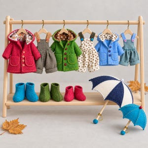 May include: A wooden clothing rack displays miniature doll outfits including three hooded coats in red, green, and blue, three pairs of overalls, three pairs of felt booties in blue, green, and red, and two small umbrellas in blue and white.