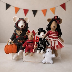 Op de afbeelding: Vier vilten muispoppen in Halloween-kostuums. Eén draagt een zwarte cape met capuchon en draagt een oranje pompoenemmer. Een andere is een rode duivel met een drietand. Een derde draagt een skeletpak en een hoge hoed.