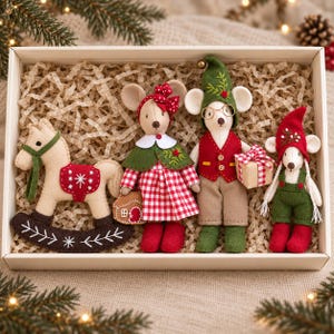May include: A set of four felt ornaments in a box: a beige rocking horse with red accents, a mouse in a red gingham dress and green cape, a mouse in a green hat and red vest holding a gift, and a small mouse in a red hat and green overalls.