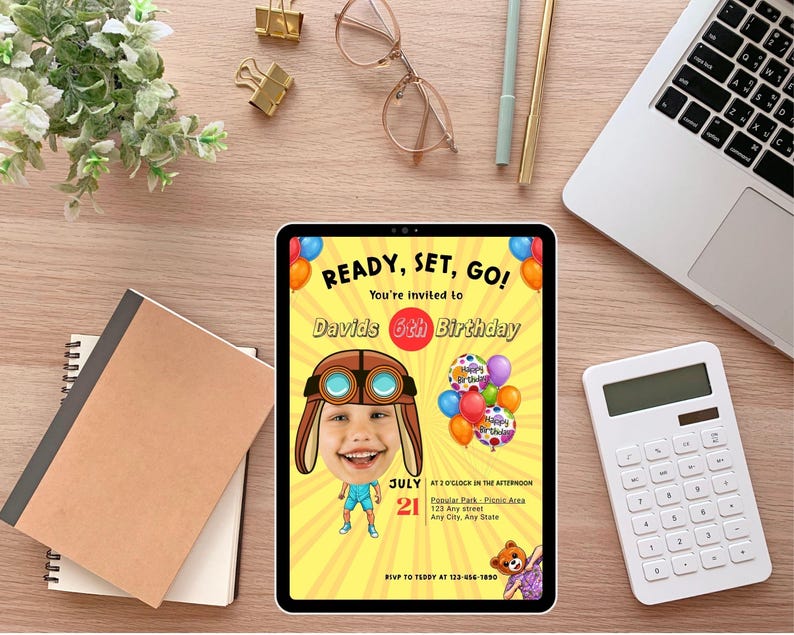 K&ouml;nnte beinhalten: Eine digitale Einladung auf einem Tablet zum 6. Geburtstag von David, mit einem Cartoon-Flieger und Luftballons. Der gelbe Hintergrund tr&auml;gt den Text "READY, SET, GO!" und Veranstaltungsdetails. Weitere Gegenst&auml;nde auf der Holzoberfl&auml;che sind ein Laptop, ein Taschenrechner und Schreibwaren.