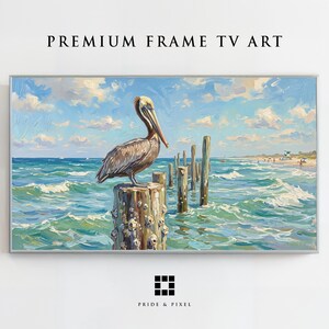 以下が含まれることがあります： PREMIUM FRAME TV ARTと題された長方形のデジタルアートプリント。ターコイズブルーの海に浮かぶ風化した木の杭の上に止まる茶色のペリカンが描かれています。砂浜、雲のある青い空、そしてPRIDE & PIXELというテキストが含まれています。
