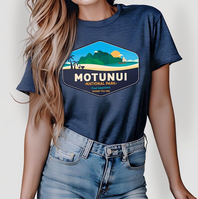 May include: Dark blue t-shirt with a graphic of a coastal scene and the words "MOTUNUI NATIONAL PARK". The design includes mountains, a beach, and a sunset. The shirt is made of a soft fabric, ideal for everyday wear.