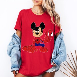 Op de afbeelding: Rood T-shirt met Mickey Mouse als Spider-Man. Het ontwerp toont Mickey in een Spider-Man-kostuum, met rode en blauwe kleuren. Het shirt heeft korte mouwen en een ronde halslijn.