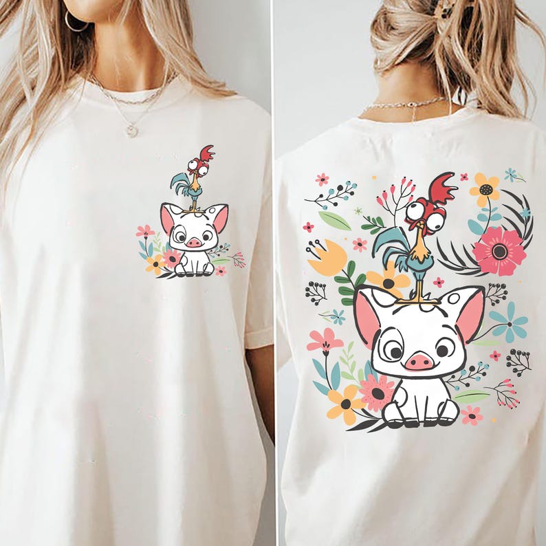 May include: Cream-colored t-shirt featuring a cartoon pig with a rooster on its head, surrounded by colorful flowers. The design is repeated on the back. A casual, comfortable tee.