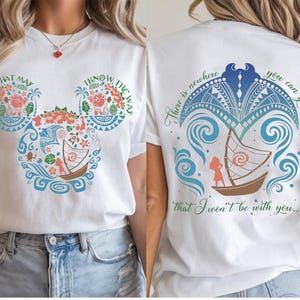 May include: White t-shirt featuring a colorful design inspired by a Disney movie. The front displays a Mickey Mouse head shape with floral and nautical elements, and the text "WHAT MAY" and "I KNOW THE WAY". The back has a boat design and the text "There is nowhere you can go that I won't be with you..."