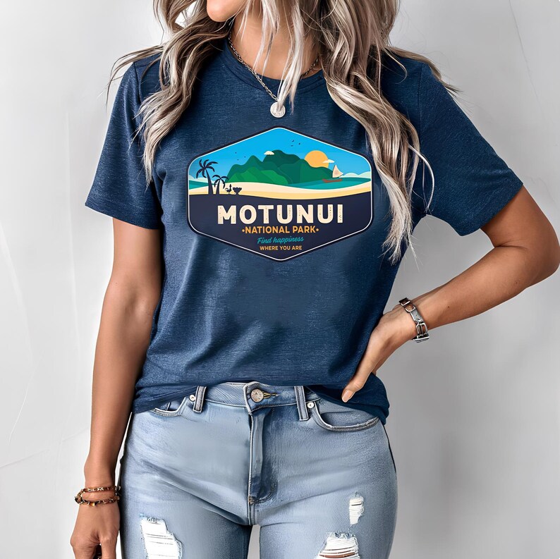 May include: A navy blue t-shirt with a hexagonal graphic displaying "MOTUNUI NATIONAL PARK". The design shows a beach scene with palm trees, mountains, and a sailboat. The text "Find happiness where you are" is also included on the shirt.