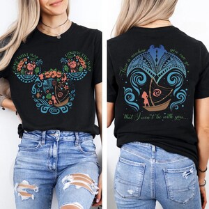 May include: Black t-shirt with a colorful graphic design featuring a boat, floral elements, and text. The front design is shaped like Mickey Mouse ears with the words "COME WHAT MAY" and "I KNOW THE WAY". The back has a boat design and the words "There is nowhere you can be that I won't be with you..."