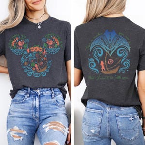 May include: Dark gray t-shirt featuring a colorful design of a boat and floral elements in the shape of Mickey Mouse ears on the front. The back of the shirt has a matching design with text. The shirt is made of a soft material.