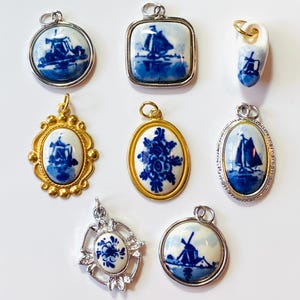 Puede incluir: Ocho colgantes de cerámica azul y blanca de Delft con varios diseños, incluyendo molinos de viento, barcos y motivos florales. Los colgantes están hechos de porcelana y tienen detalles plateados u dorados.