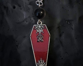 Collar con colgante de ataúd de esmalte rojo y cuentas de vidrio.