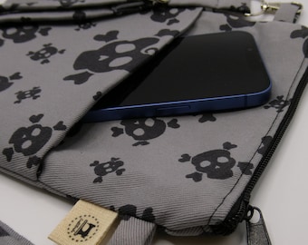 Bolso bandolera artesanal con calavera gris, estilo gótico.