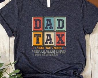 May include: A heather navy blue t-shirt with a retro-style graphic that says "DAD TAX" and a definition of the term. The definition reads: "Portion of an item a Dad is entitled to when he buys something for his kids. Ensures food isn't poisonous."