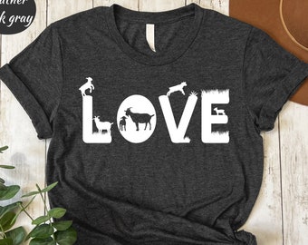 Peut inclure: Un t-shirt gris foncé chiné avec le mot "LOVE" écrit en blanc. Chaque lettre est formée par une silhouette de chèvre.