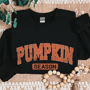 a black shirt with a pumpkin design on it
