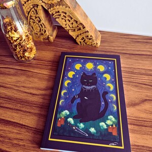 Peut inclure: Un chat noir aux yeux verts assis sur un champ vert avec un couteau et des bougies. Le chat porte un collier argenté et a une lune croissante et le soleil derrière lui. L'arrière-plan est bleu foncé avec des étoiles jaunes et des lunes croissantes.