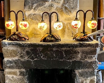 Lampada a forma di orchidea in miniatura con doppi globi di vetro decorati con immagini di orchidee, base dipinta con patina color rame con foglie e radici, scala 1:12.