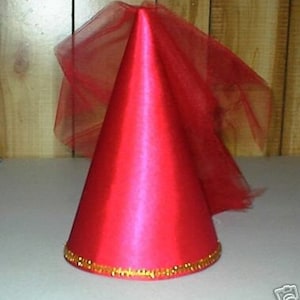 May include: A bright red cone-shaped party hat with a gold beaded trim around the base. A sheer red fabric is attached to the top, flowing down the side. The hat is made of a shiny, satin-like material.