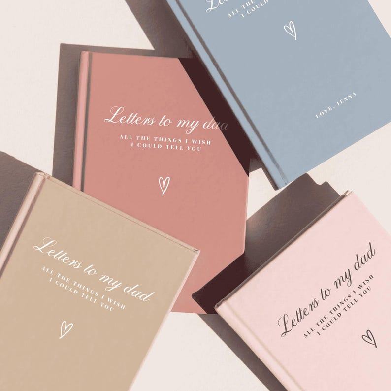 May include: Four hardcover journals in dusty rose, light blue, beige, and soft pink. Each cover features the white or black text Letters to my dad, All the things I wish I could tell you, and a small hand-drawn heart icon centered below the text.