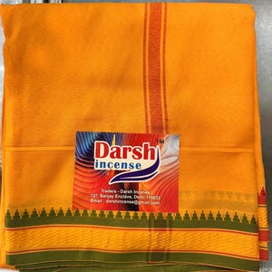 Puede incluir: Tela de color naranja brillante con un borde verde y naranja. Una tarjeta de visita con el texto "Darsh incense" está sobre la tela. La tela tiene rayas naranjas y rojas.