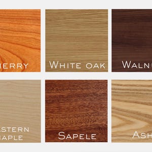 May include: A grid of six wood grain samples labeled Cherry, White Oak, Walnut, Eastern Maple, Sapele, and Ash. Each square displays a distinct natural wood color and texture, ranging from light beige and tan to reddish-brown and dark brown tones.