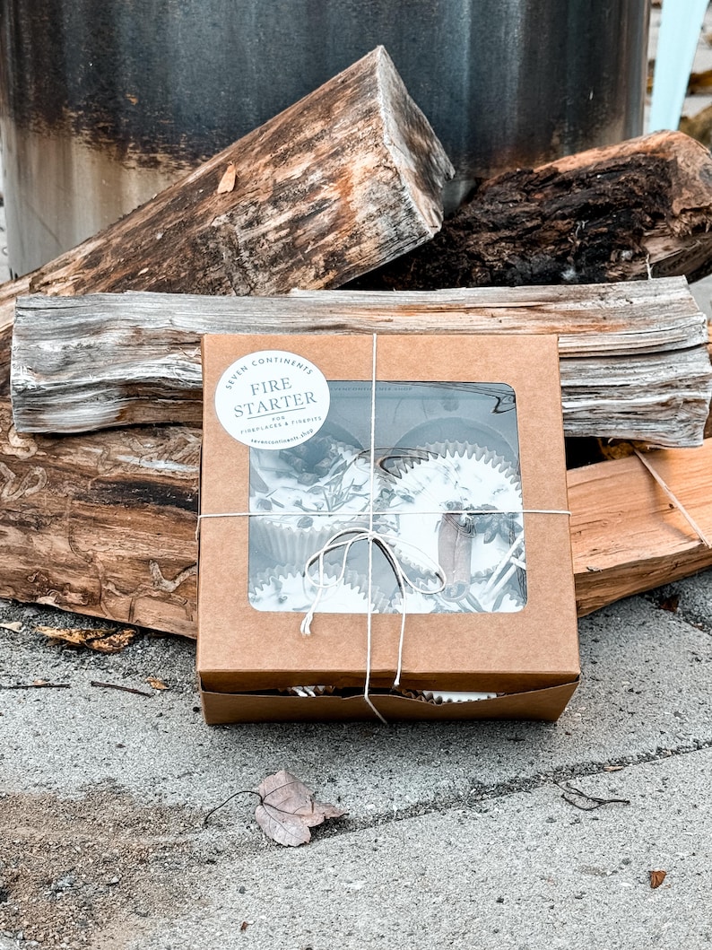 May include: A brown cardboard box with a clear window showing fire starter logs inside. The box is tied with twine and has a white label that says "Fire Starter for Fireplaces & Firepits".