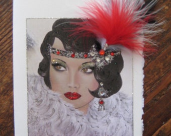 May include: A vintage-inspired greeting card featuring a woman with dark hair and a red feather headband. She is wearing a white fur collar and has a jeweled earring. The card has a white background and a silver glitter border.