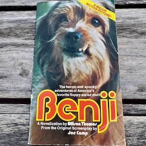 May include: A vintage paperback book titled "Benji" with a dog's face on the cover. The title is in large orange letters with a yellow outline. The cover also includes text that reads "A Major Motion Picture!"