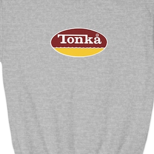 May include: A gray sweatshirt with a red and yellow oval logo that says "Tonka" in white letters.