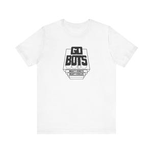 May include: White t-shirt with a black graphic design that says "GO BOTS" with the text "MIGHTY ROBOTS" and "MIGHTY VEHICLES" underneath.