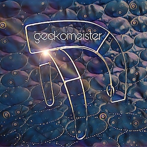 May include: A silver metal frame with the word "gecko meister" printed on it. The frame is shaped like a half circle and is sitting on a blue and purple patterned surface.