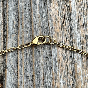 May include: Gold chain necklace with a lobster clasp closure.