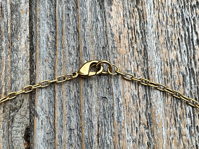 May include: Gold chain necklace with a lobster clasp closure.