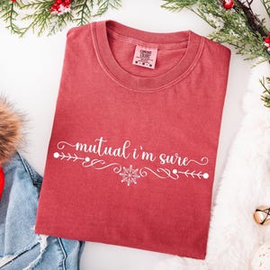 Crimson Comfort Colors unisex tshirt with a text based design in cursive white lettering it says - Mutual I'm Sure.  Underneath there is a snowflake in center of a flourished line.  Mutual I'm Sure statement shirt, Classic movie shirt, movie quote t-shirt, mutual i'm sure tshirt, Trendy holiday tee.