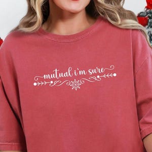 Crimson Comfort Colors unisex tshirt with a text based design in cursive white lettering it says - Mutual I'm Sure.  Underneath there is a snowflake in center of a flourished line.  Mutual I'm Sure statement shirt, Classic movie shirt, movie quote t-shirt, mutual i'm sure tshirt, Trendy holiday tee.