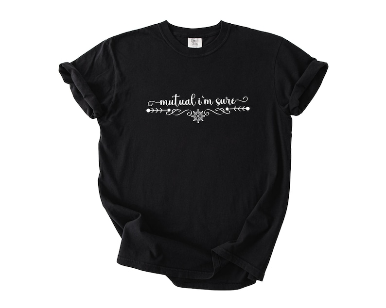 Puede incluir: Una camiseta negra de manga corta con el texto blanco "mutual i'm sure" impreso en el pecho. El texto est&aacute; centrado y flanqueado por adornos blancos decorativos y un peque&ntilde;o icono en forma de copo de nieve debajo de las palabras.