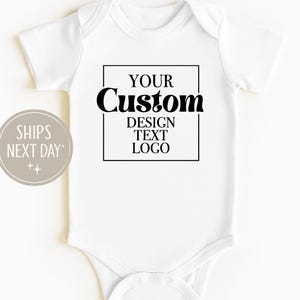 以下が含まれることがあります： 黒いテキストデザインの白いベビーボディスーツ。黒い長方形の中に「YOUR Custom DESIGN TEXT LOGO」と書かれています。左側の円形グラフィックには「SHIPS NEXT DAY」と書かれています。