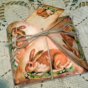Puede incluir: Una caja de regalo de papel marrón con un diseño de conejo. La caja está atada con cuerda y tiene un aspecto vintage.
