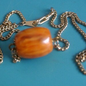 Pendant necklace with genuine tested vintage 1950s flamy swirled goldbrown bakelite plastic barrel bead and brass chain with lobster clasp