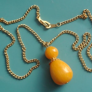 Pendant necklace of goldcolor metal chain and butterschotch yellow drop-formed/ round genuin tested 1940s bakelite plastic bead