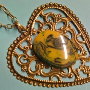 Pendant necklace with genuine tested vintage 1950s flamy swirled dark green/ butteryellow bakelite plastic cabochon and bronze heart