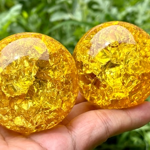Peut inclure: Deux sphères de verre jaune doré avec une finition texturée, scintillante et pailletée. Les sphères sont à peu près de la taille d'une balle de golf.