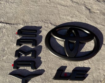Nakładki na emblematy Toyota Camry LE 2018–2024 • Czarne logo Camry LE • Ulepszenie wyglądu zewnętrznego