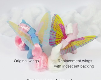 Könnte beinhalten: Zwei Paar Schmetterlingsflügel für My Little Pony Spielzeug. Die Flügel links sind original, während die Flügel rechts Ersatzflügel mit irisierendem Rücken sind. Ponys nicht enthalten.
